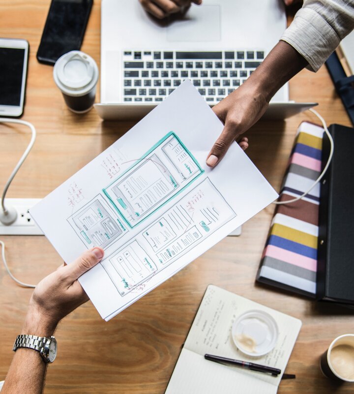 Handoff of mobile app sketches over desk